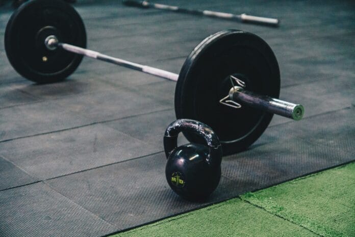 Sztanga i kettlebell leżące na podłodze siłowni Sztanga i kettlebell leżące na podłodze siłowni